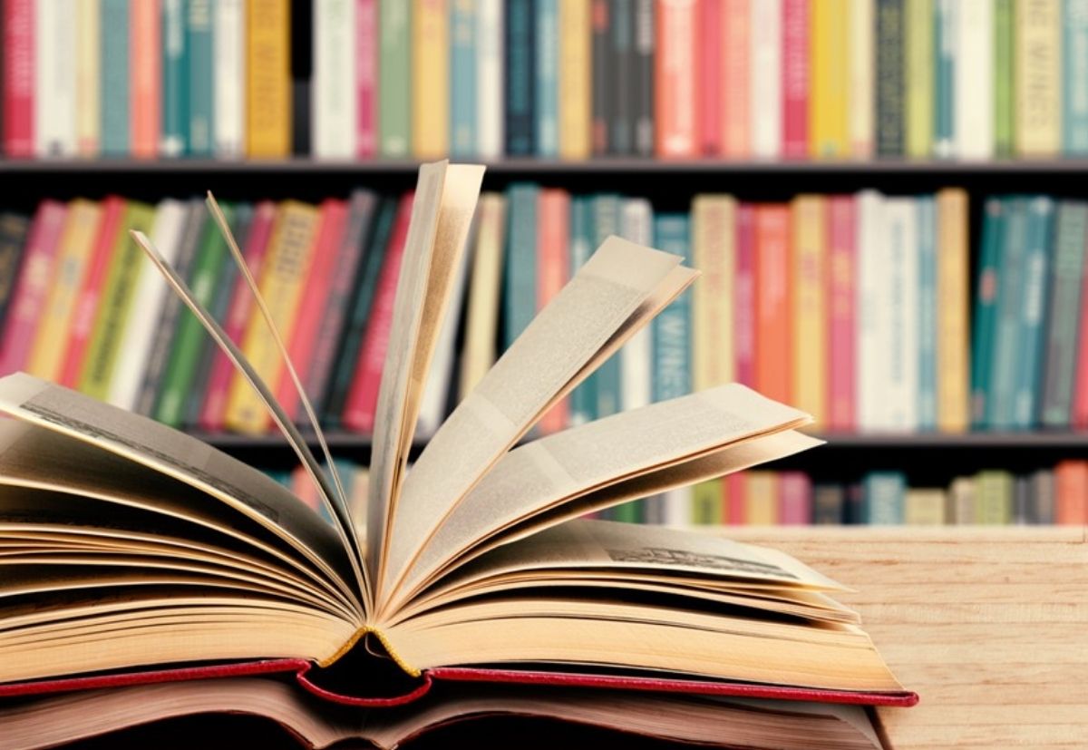 Open book with a colorful bookshelf in the background